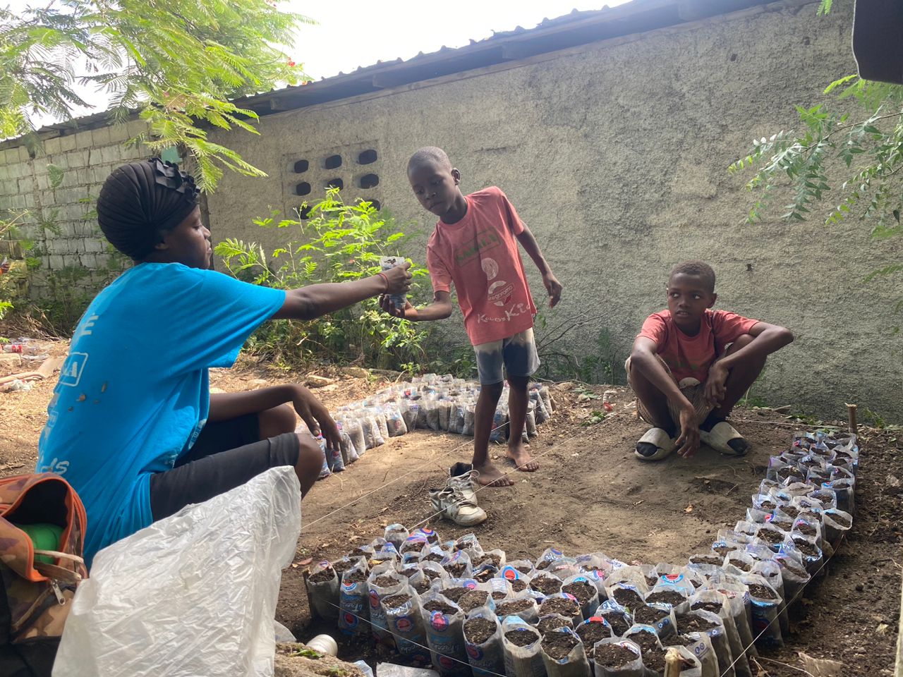 SAKALA mentor teaching younger participants at the cooperative nursery, hands-on knowledge transfer